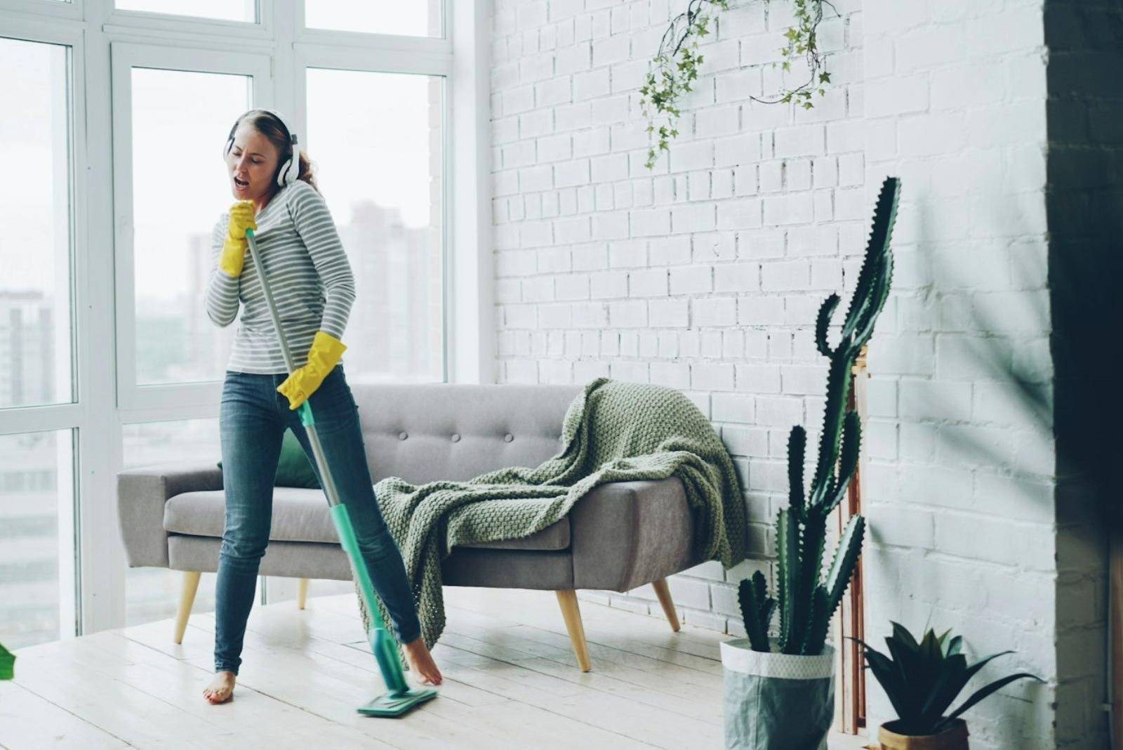 A cleaner enjoying her work in a bright flat
