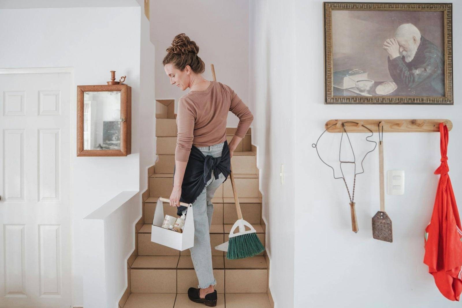 A Renovo cleaner carrying a caddy of products through a home