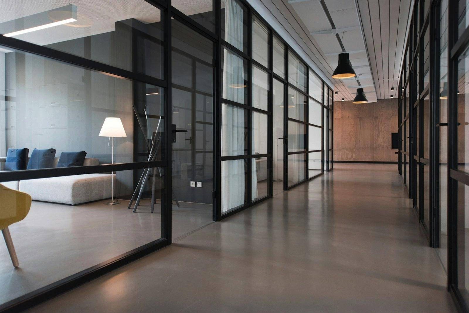 A modern office with glass partitions and clean floors